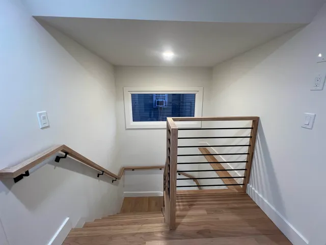 a view of room with stairs and wooden floor