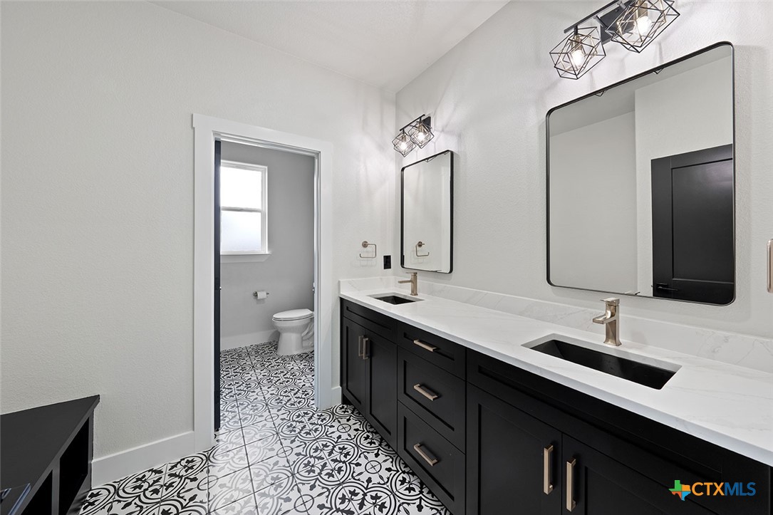 1220 Hadley Lane Copperas Cove, TX 76522 - Photo 12 of 17 a bathroom with a double vanity sink mirror and toilet