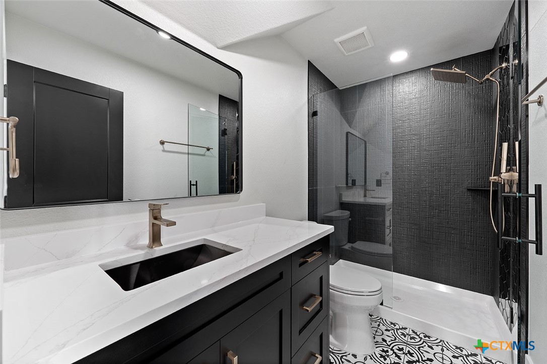 1220 Hadley Lane Copperas Cove, TX 76522 - Photo 10 of 17 a bathroom with a sink a toilet a mirror and shower