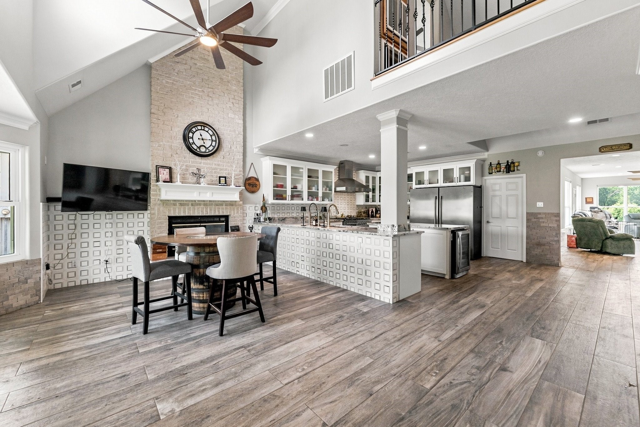 9010 Point Barrow Road Beach City, TX 77523 - Photo 3 of 50 The open-concept main living area makes an immediate impression with soaring cathedral ceilings, an open second-floor overlook, porcelain tile flooring & a dramatic brick wood-burning fireplace anchoring the space.