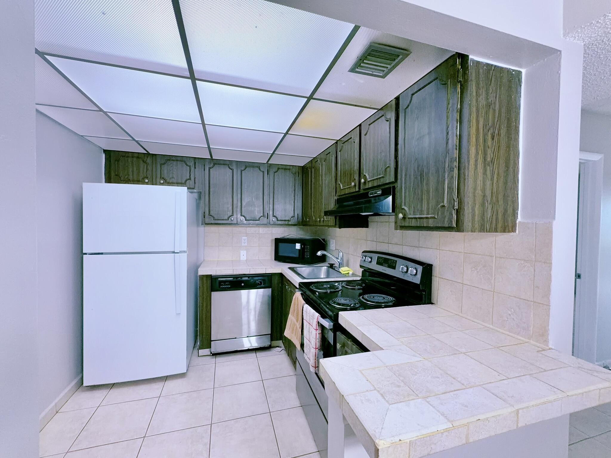 a kitchen with a stove a refrigerator and cabinets
