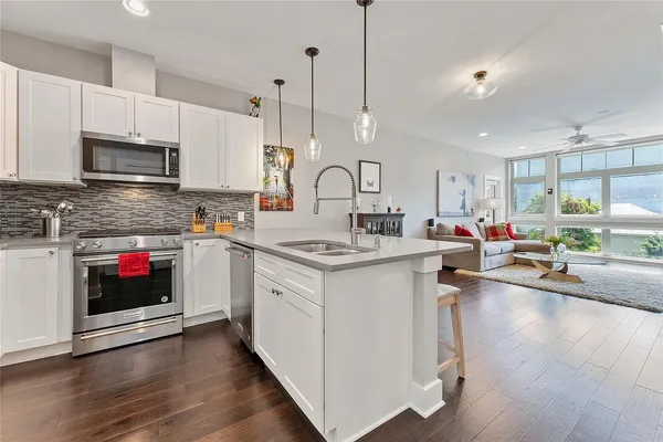 a kitchen with stainless steel appliances granite countertop a stove a microwave and cabinets