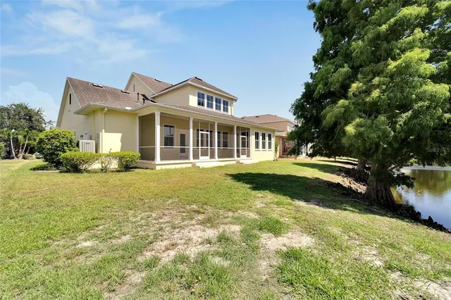 a view of an empty room with chandelier fan and a window