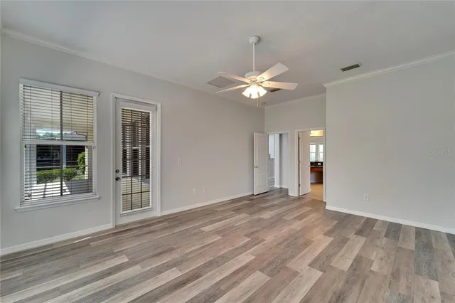 a large white kitchen with kitchen island a sink dishwasher a refrigerator and white cabinets with wooden floor