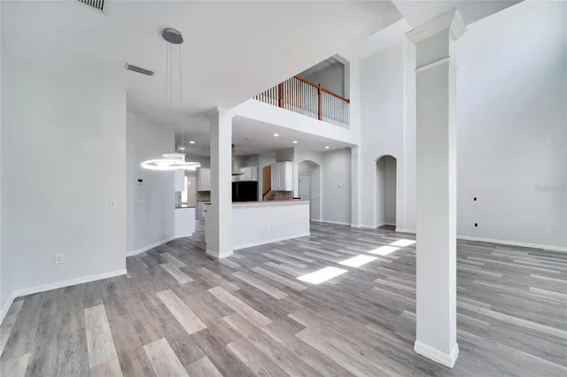 an empty room with a ceiling fan and windows