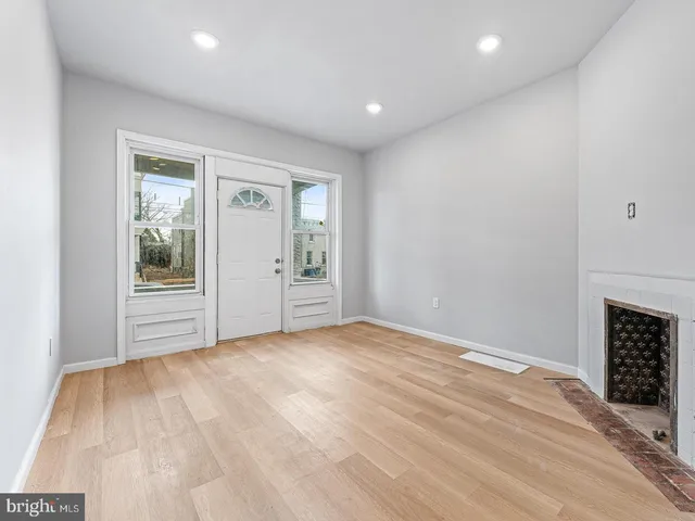 a view of an empty room with a fireplace and a window