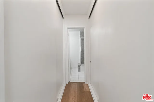 a view of a hallway with wooden floor