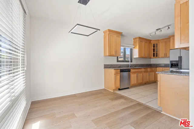 a kitchen with stainless steel appliances granite countertop a stove a sink and a refrigerator