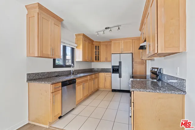 a kitchen with stainless steel appliances granite countertop a sink counter space cabinets and a large window
