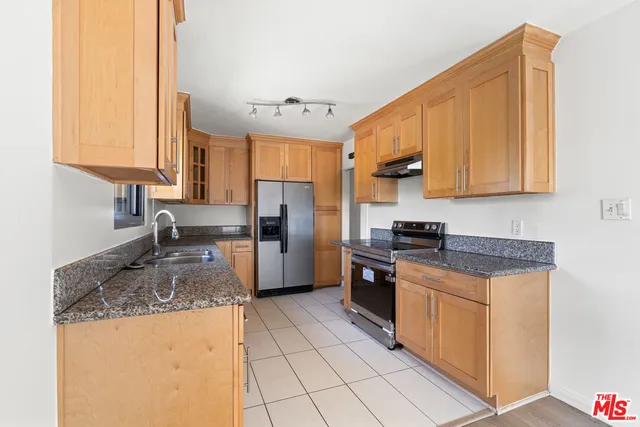 a kitchen with stainless steel appliances granite countertop a stove a sink dishwasher and a refrigerator