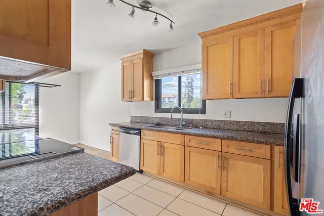 a kitchen with granite countertop sink and cabinets