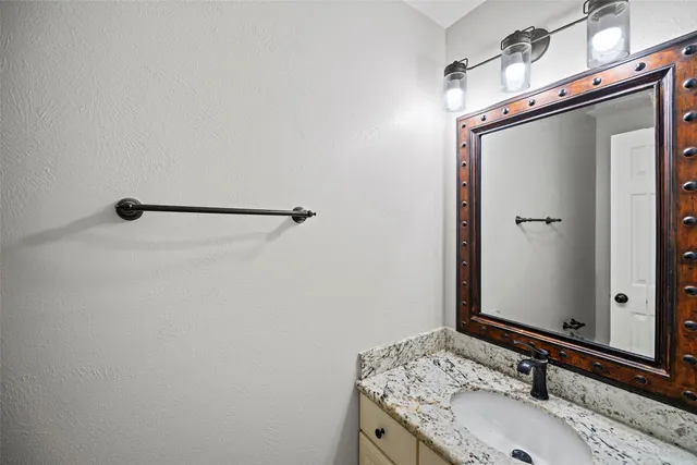 a bathroom with a granite countertop sink and a mirror