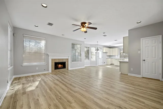 a view of a livingroom with a fireplace a chandelier and wooden floor