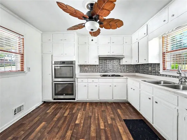 a kitchen with a refrigerator oven cabinets and a sink
