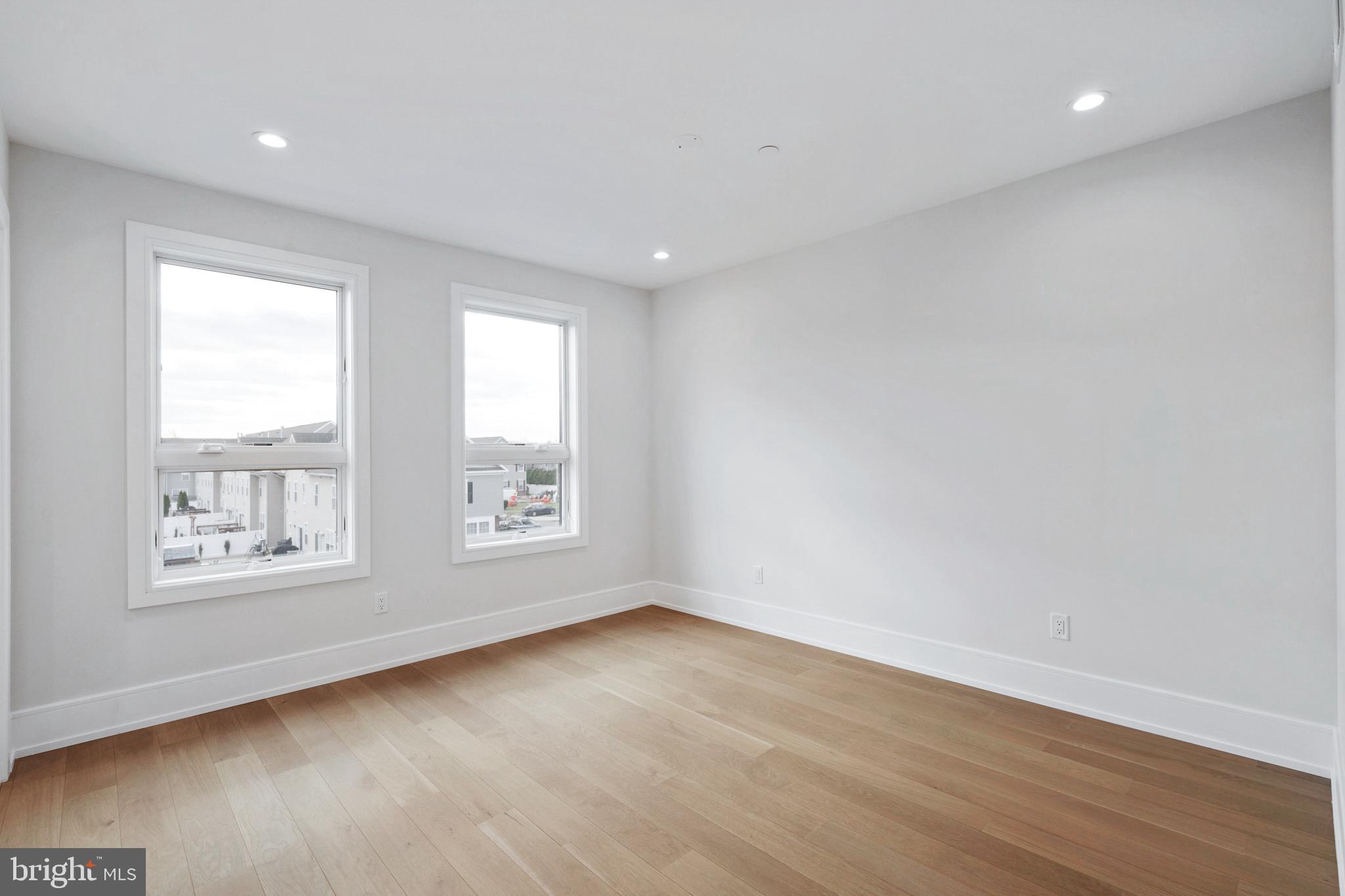 2008 Renaissance Walk, Unit 5 Philadelphia, PA 19145 - Photo 30 of 94 an empty room with wooden floor and windows
