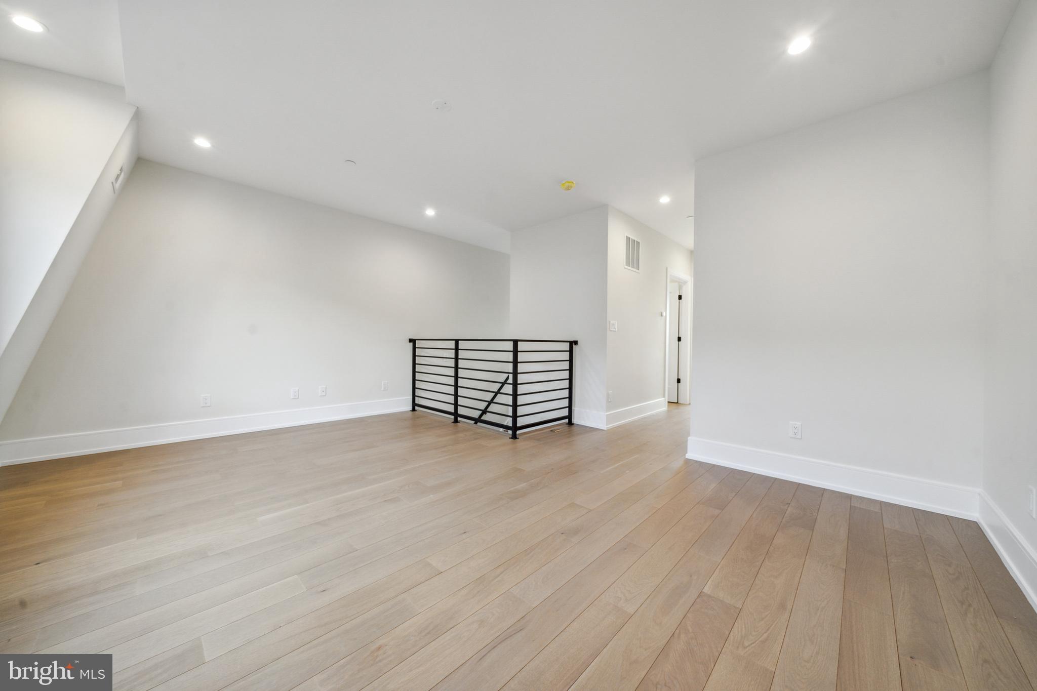 2008 Renaissance Walk, Unit 5 Philadelphia, PA 19145 - Photo 77 of 94 a view of an empty room with wooden floor and a window
