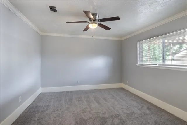 an empty room with a window and a fan