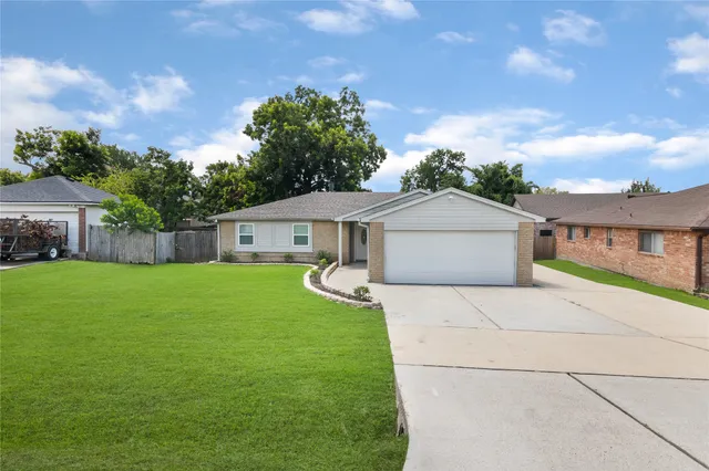 a front view of house with yard and trees in the background