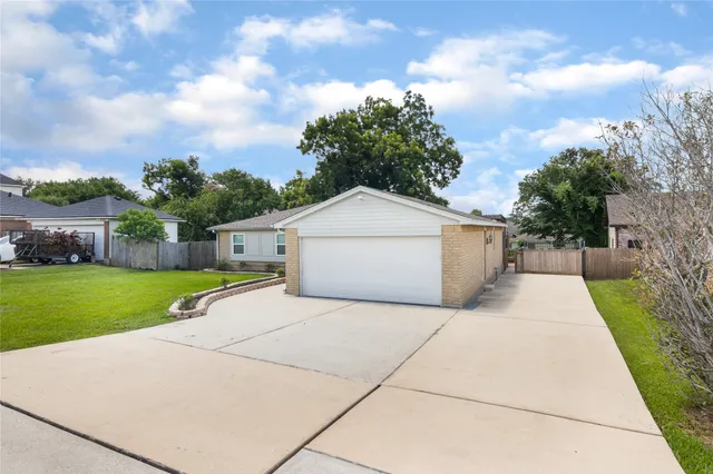 a view of a house with a yard and large tree
