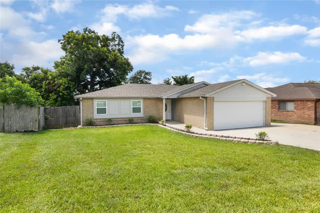 a view of a house with a yard and a garden