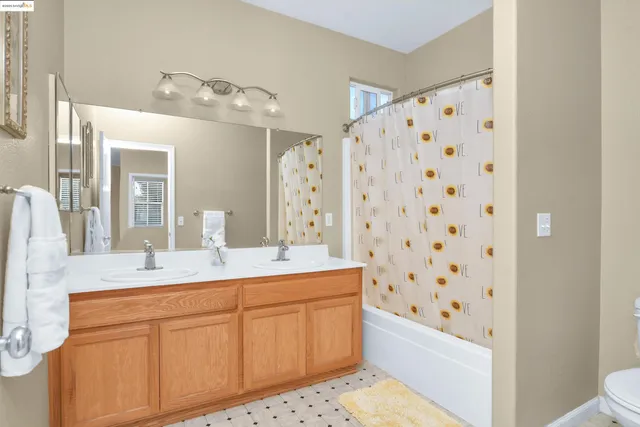 a bathroom with a sink a toilet a mirror a bathtub and shower