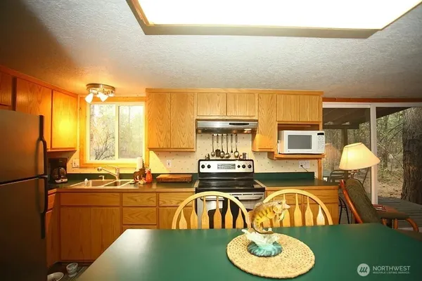 a kitchen with a table chairs stove and kitchen view