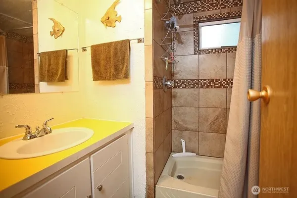 a bathroom with a granite countertop sink and a bathtub
