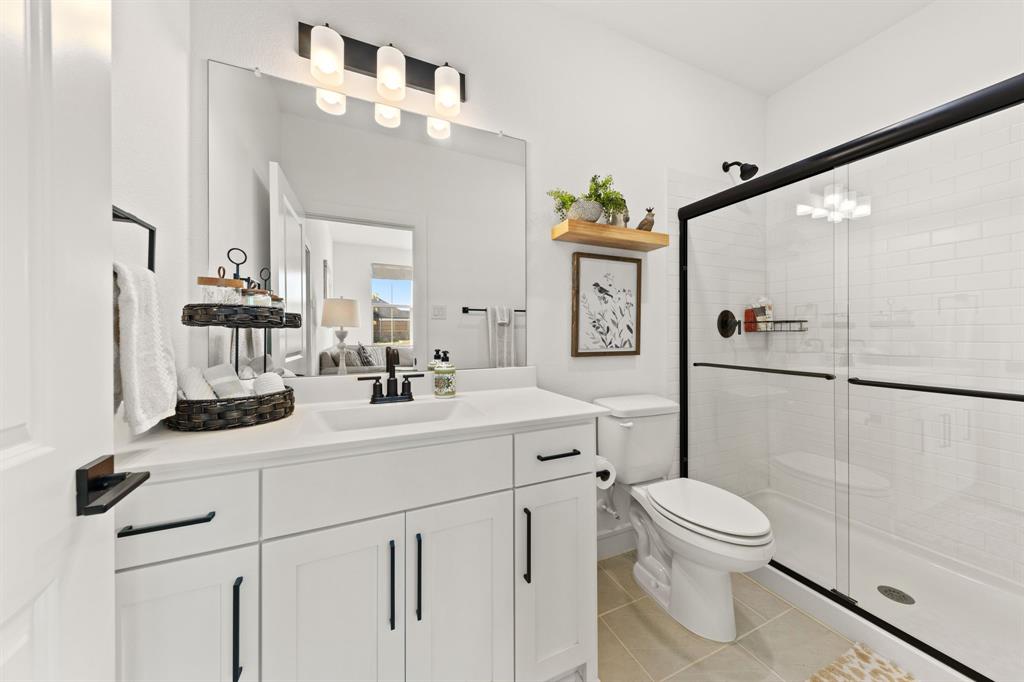1340 Cartona Road Fate, TX 75087 - Photo 9 of 32 a bathroom with a sink a toilet and shower