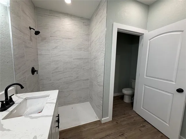 a bathroom with a sink a toilet and shower