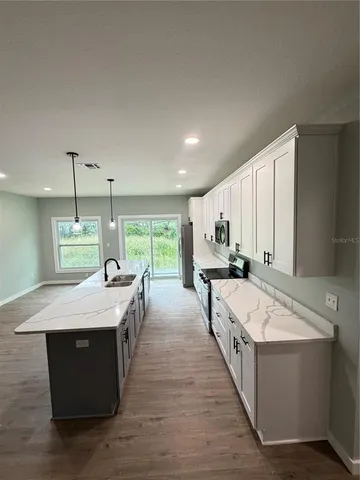 a large kitchen with kitchen island a large island in it