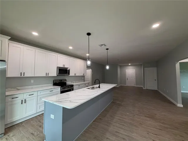 a kitchen with a sink stove and cabinets