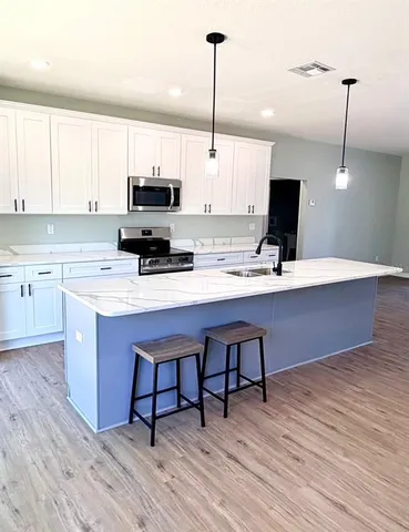 a kitchen with a sink cabinets and wooden floor
