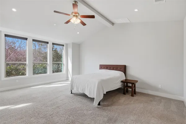 a spacious bedroom with a bed and a window