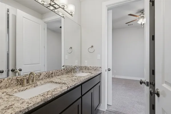 a bathroom with a granite countertop sink and a mirror