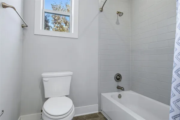 a white toilet sitting next to a bath tub
