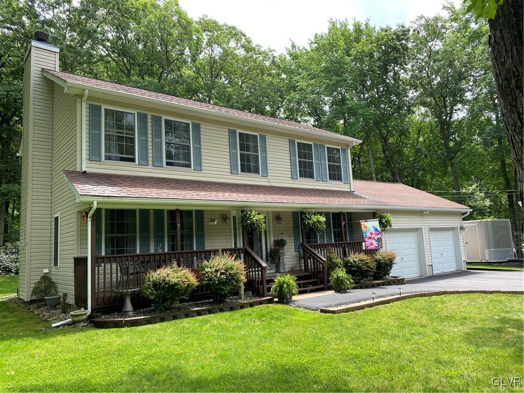 a front view of a house with a yard and potted plants