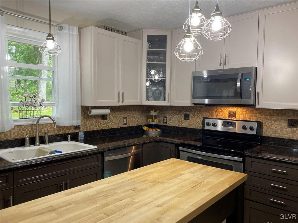 142 Colette Lane Dingmans Ferry, PA 18328 - Photo 7 of 14 a kitchen with a sink and chandelier