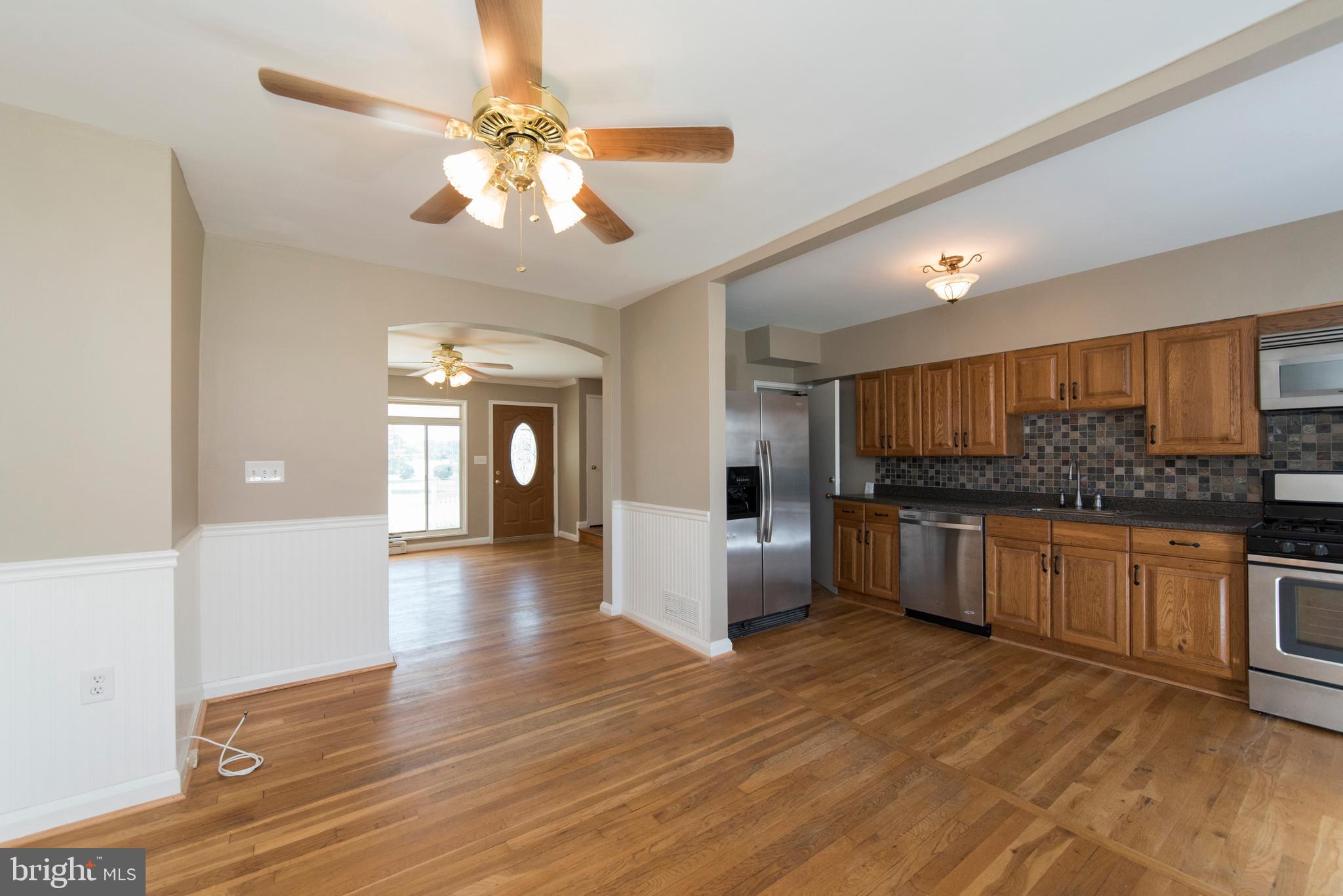 2702 Kirkleigh Road Baltimore, MD 21222 - Photo 12 of 32 a large kitchen with a sink and dishwasher a stove with wooden floor