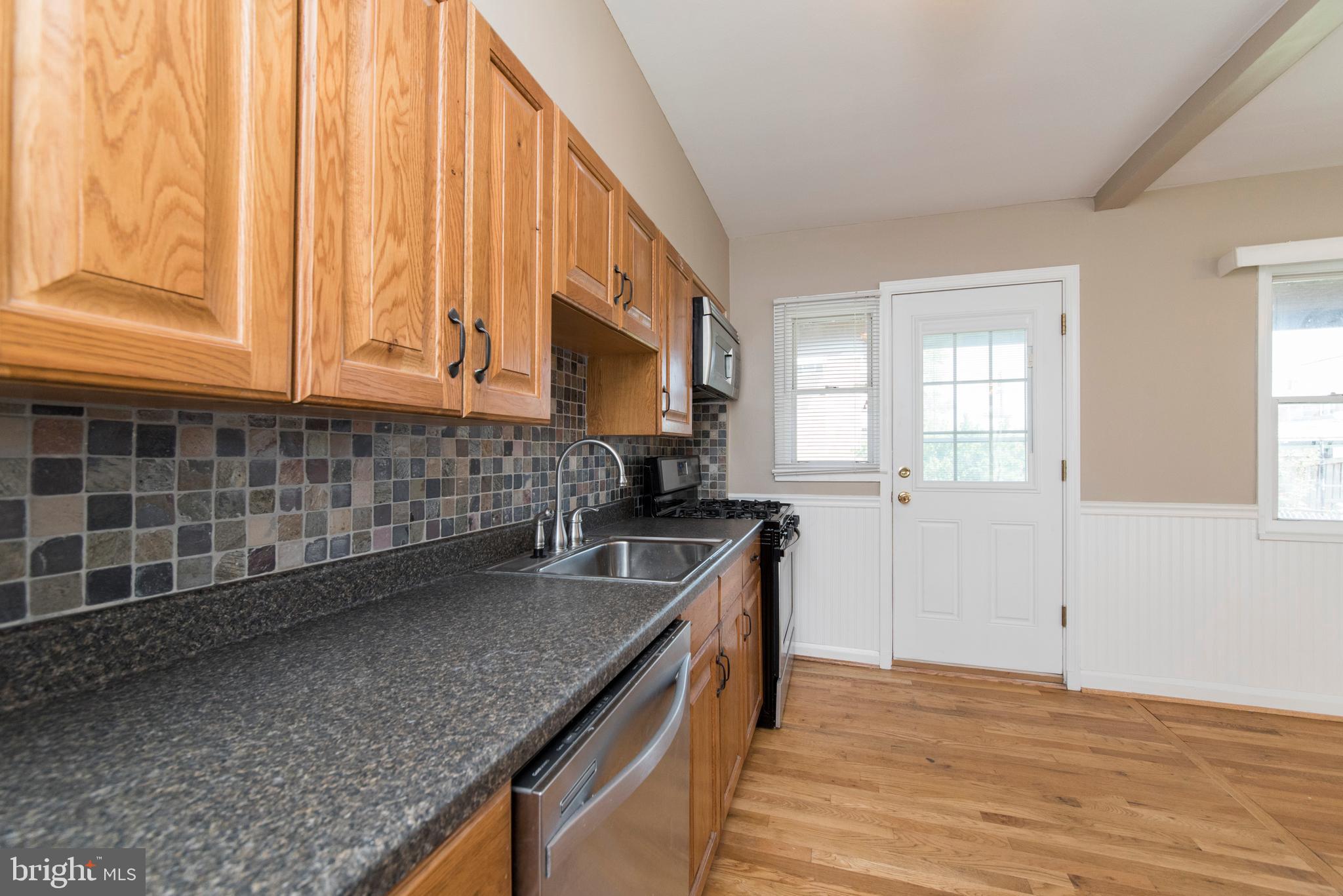 2702 Kirkleigh Road Baltimore, MD 21222 - Photo 13 of 32 a kitchen with stainless steel appliances granite countertop a sink a stove and cabinets