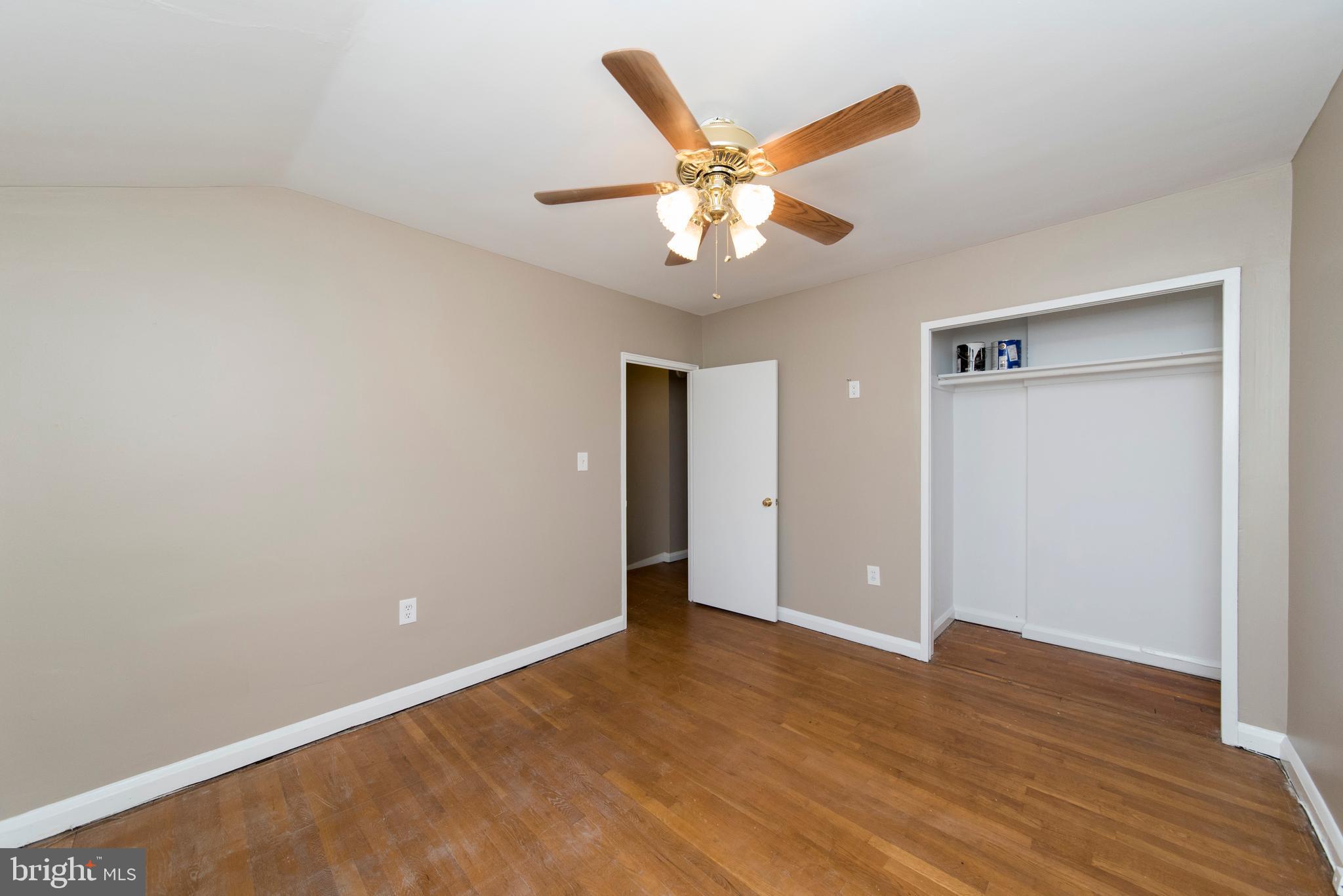 2702 Kirkleigh Road Baltimore, MD 21222 - Photo 14 of 32 an empty room with wooden floor closet and fan