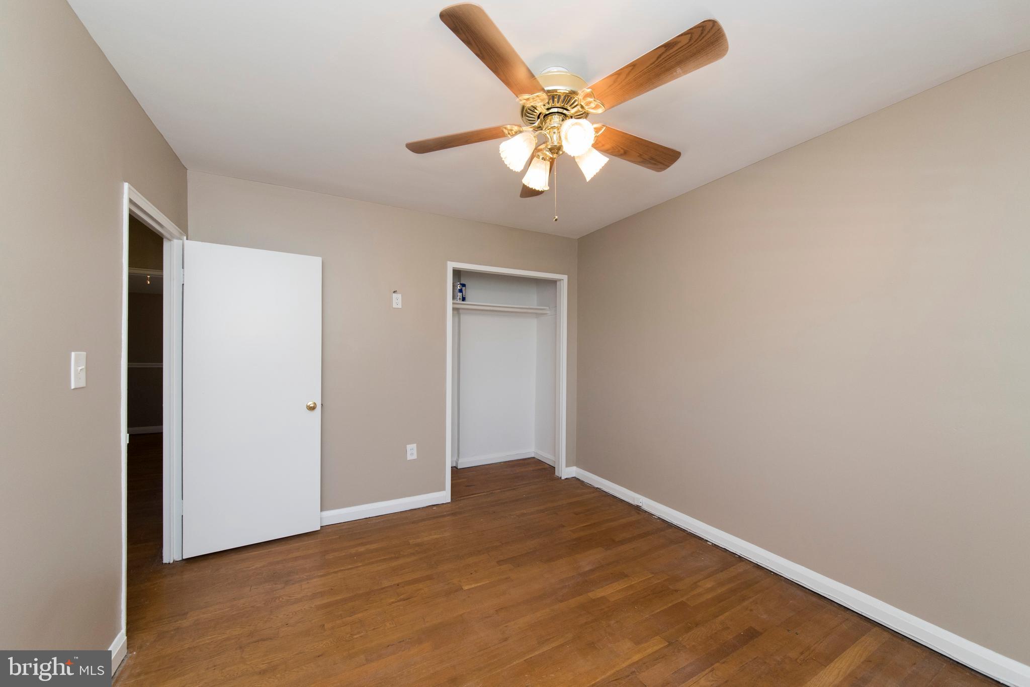 2702 Kirkleigh Road Baltimore, MD 21222 - Photo 15 of 32 an empty room with wooden floor and fan