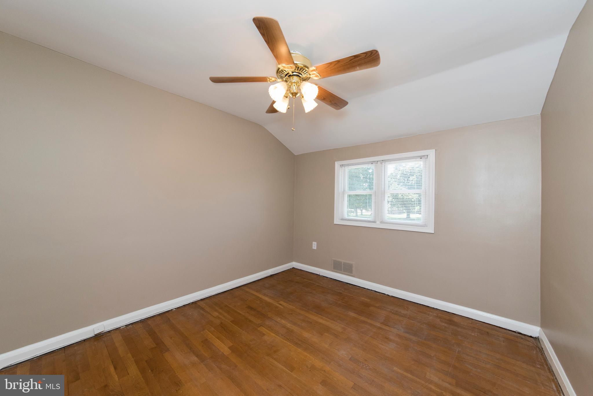 2702 Kirkleigh Road Baltimore, MD 21222 - Photo 16 of 32 wooden floor in an empty room with a window
