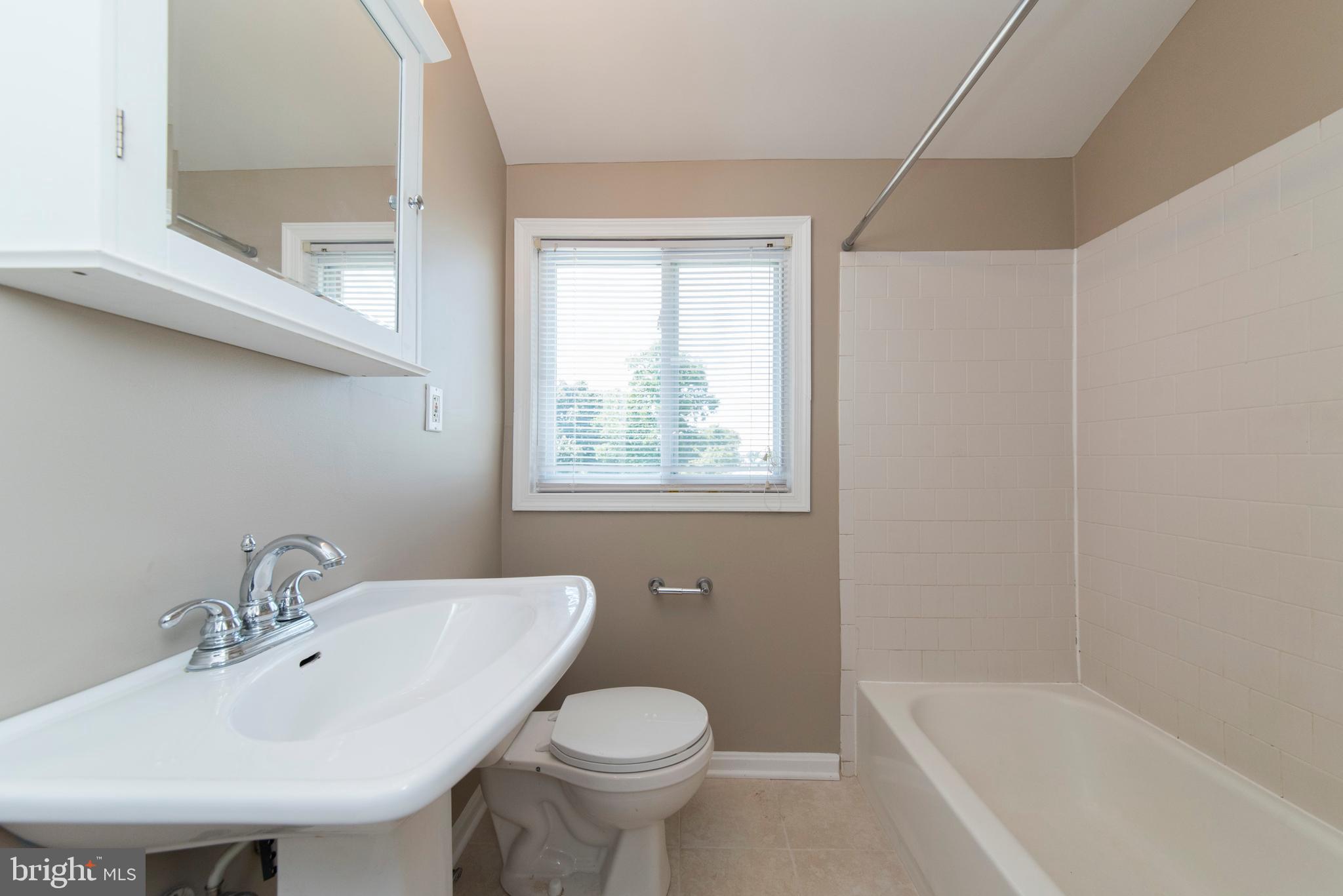 2702 Kirkleigh Road Baltimore, MD 21222 - Photo 17 of 32 a bathroom with a sink toilet and a bathtub