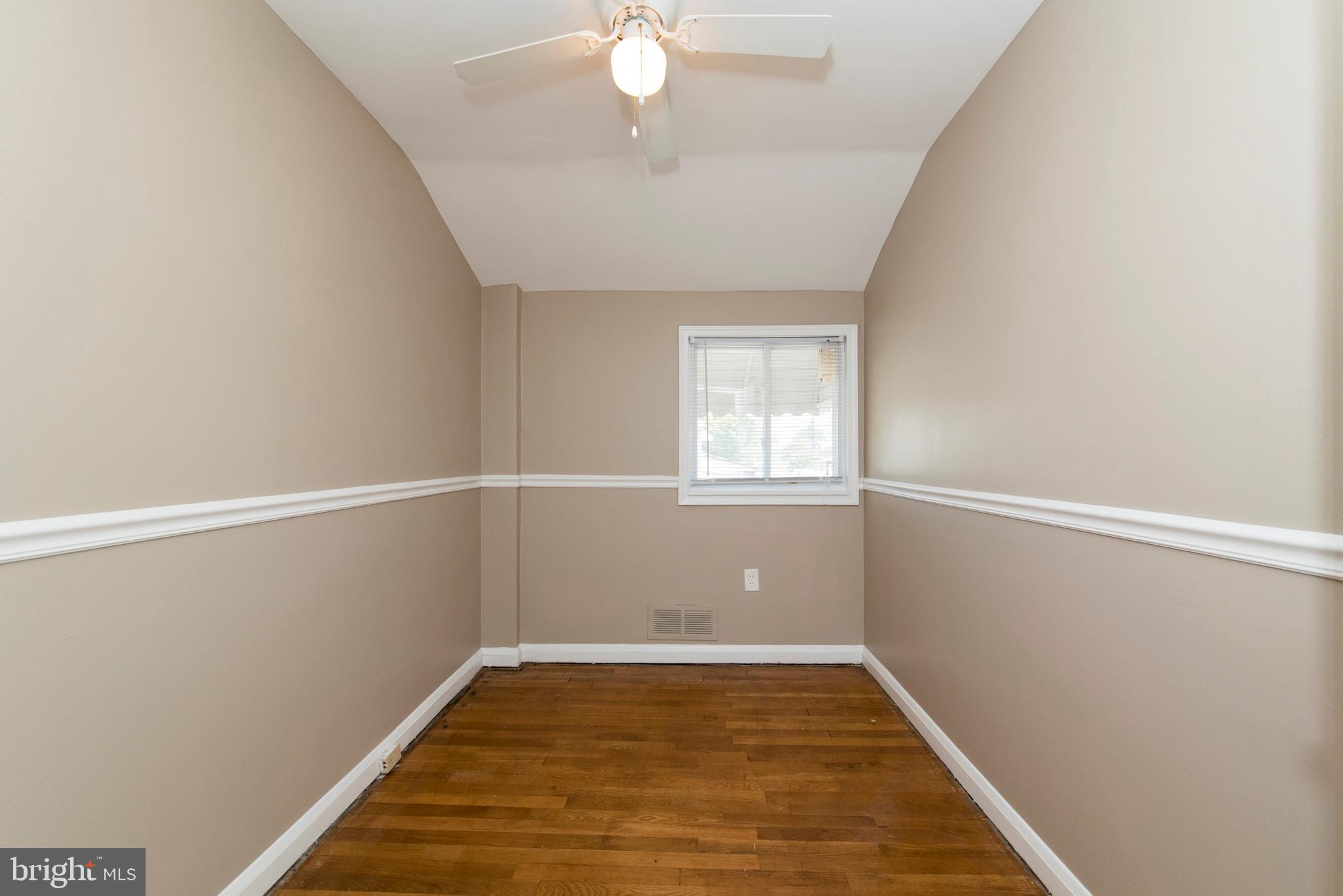 2702 Kirkleigh Road Baltimore, MD 21222 - Photo 19 of 32 wooden floor in an empty room with a window