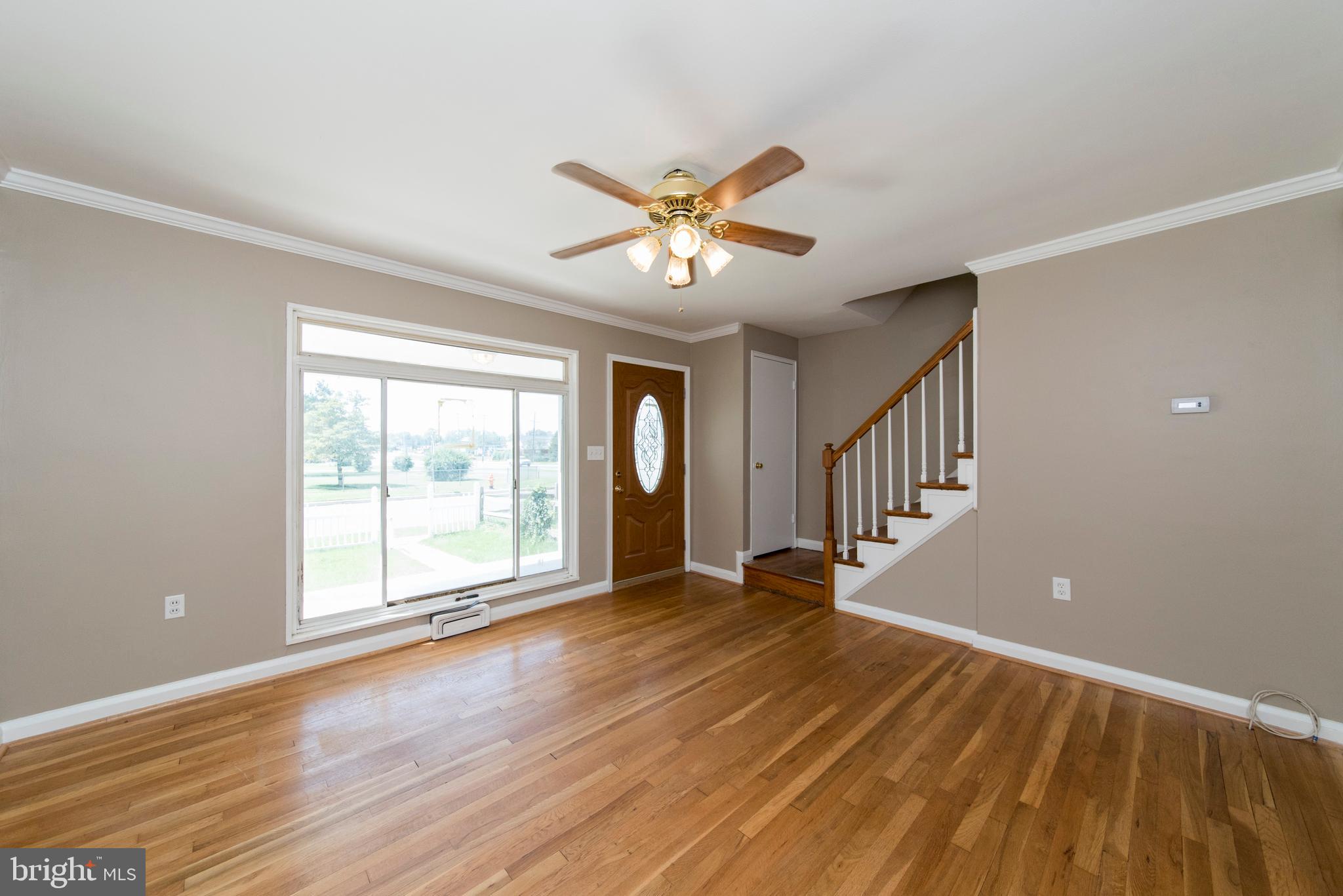 2702 Kirkleigh Road Baltimore, MD 21222 - Photo 3 of 32 a view of an empty room with a window and wooden floor