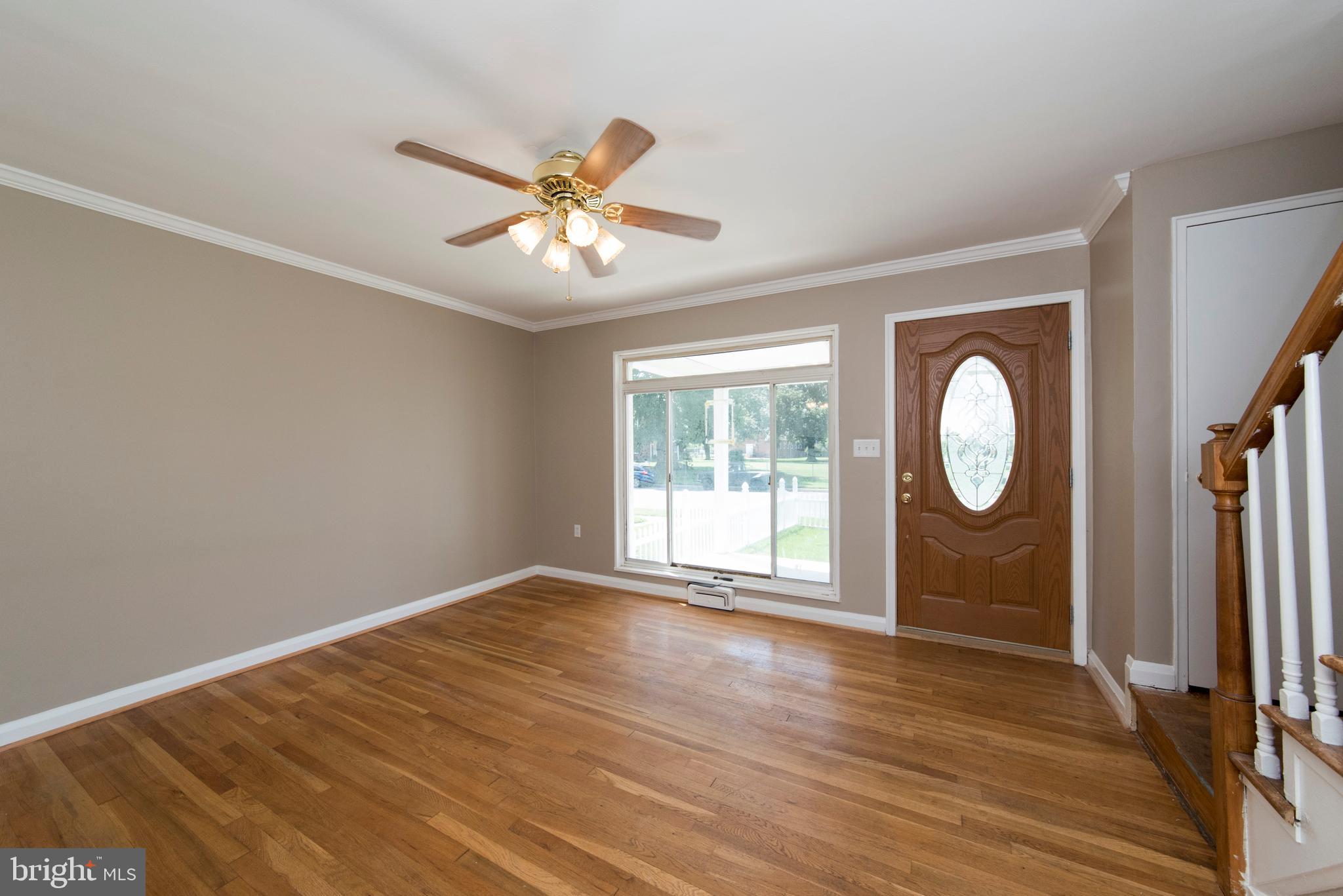 2702 Kirkleigh Road Baltimore, MD 21222 - Photo 5 of 32 a view of an empty room with wooden floor and a window