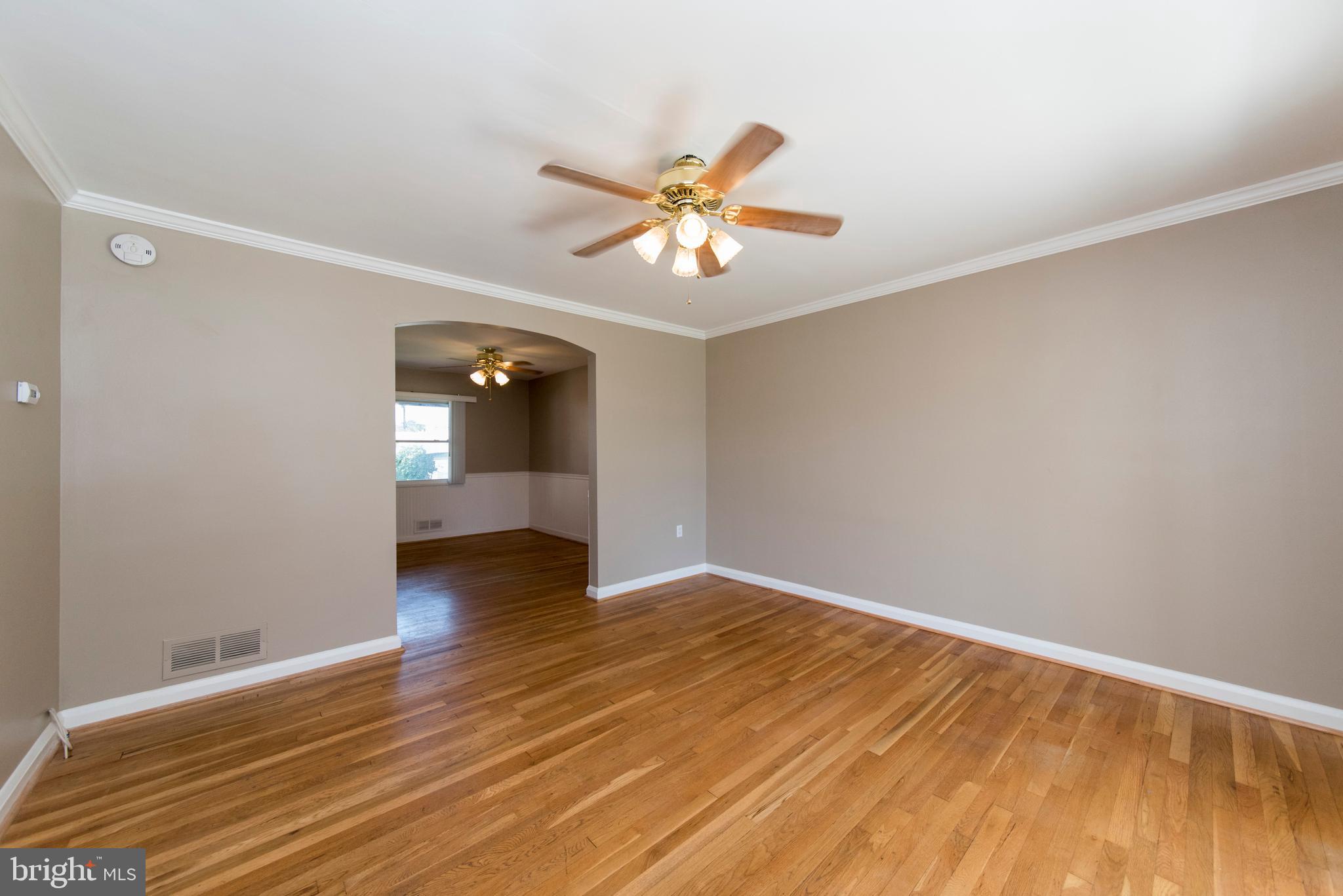 2702 Kirkleigh Road Baltimore, MD 21222 - Photo 7 of 32 a view of an empty room with window and wooden floor
