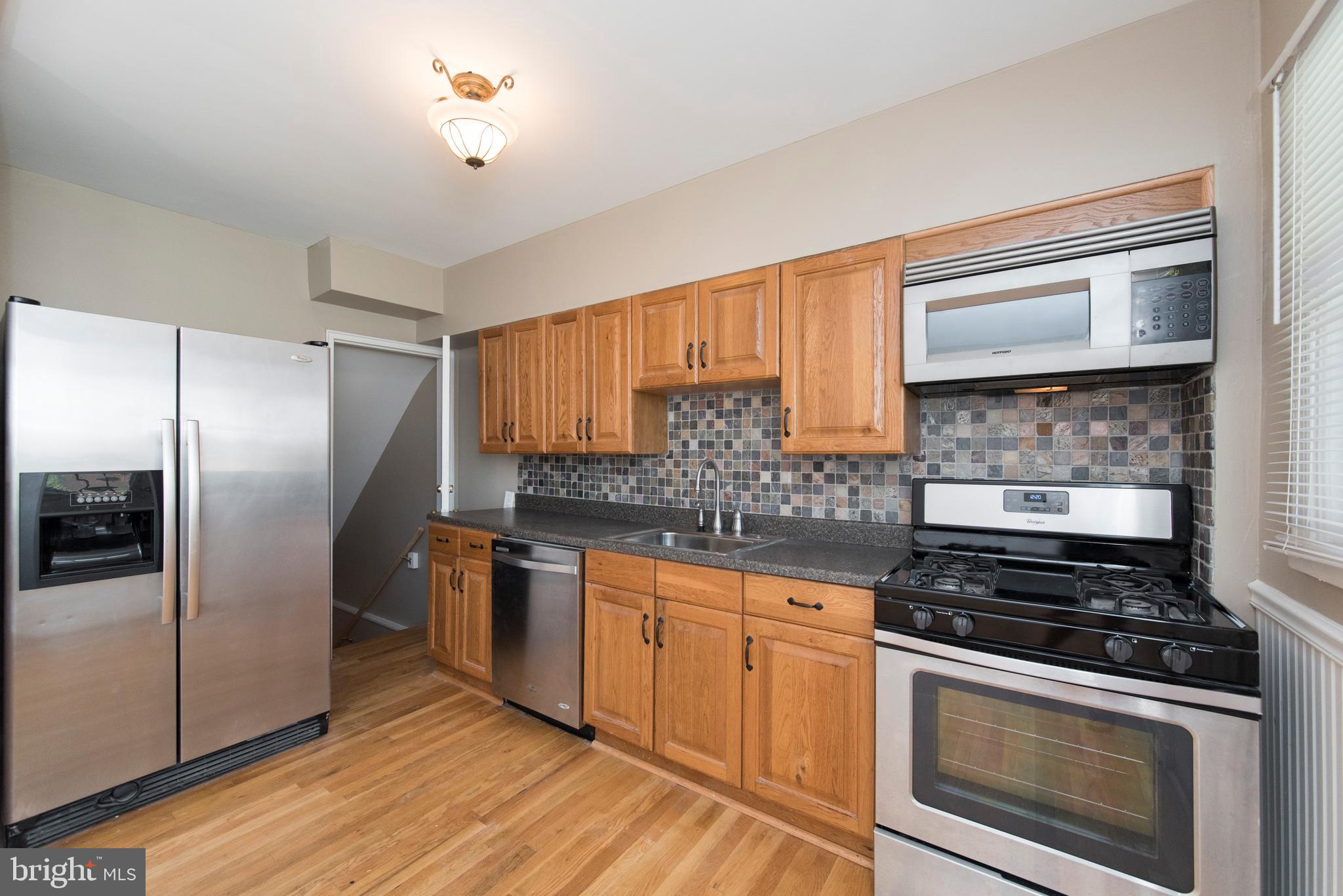 2702 Kirkleigh Road Baltimore, MD 21222 - Photo 10 of 32 a kitchen with stainless steel appliances granite countertop a stove and a refrigerator