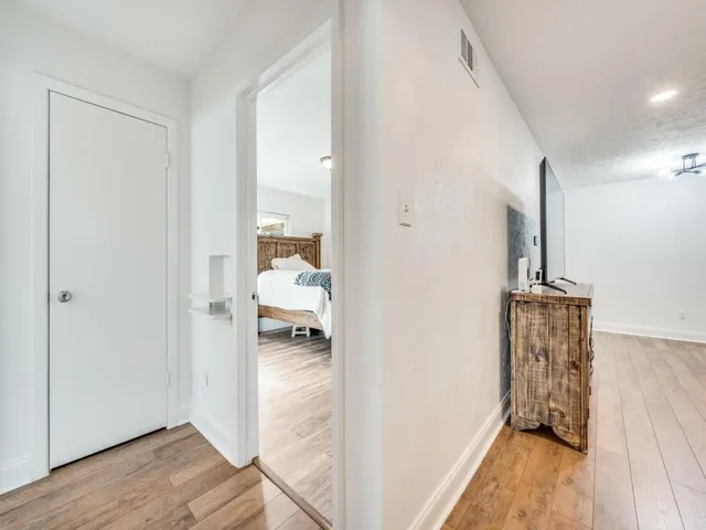 a view of a hallway to a livingroom and a hallway with wooden floor