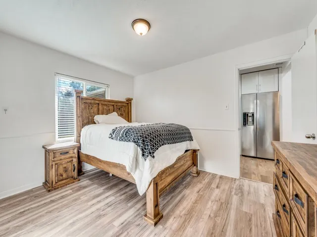 a bedroom with a bed and wooden floor